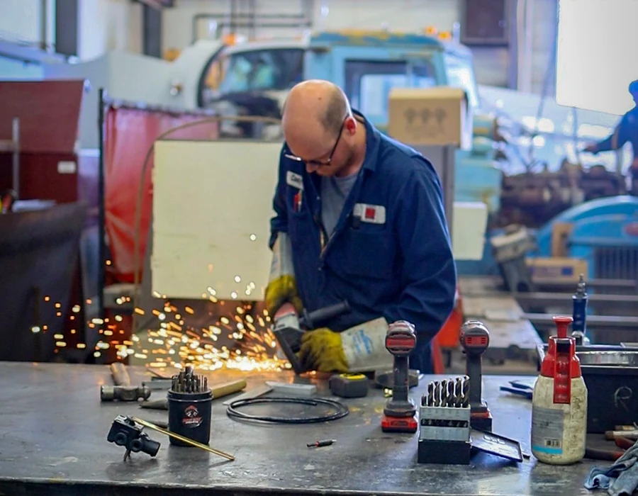 Technician fabricating a metal component in the shop